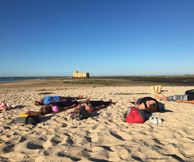 Yoga gegeven op het strand